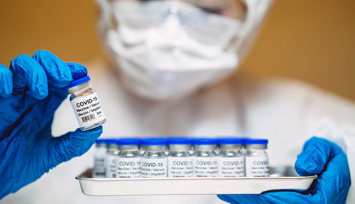 Profesional de la salud sostiene una bandeja con varios frascos de la vacuna contra la COVID-19