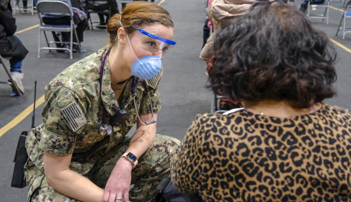A member of the military talks with a woman at a clinic