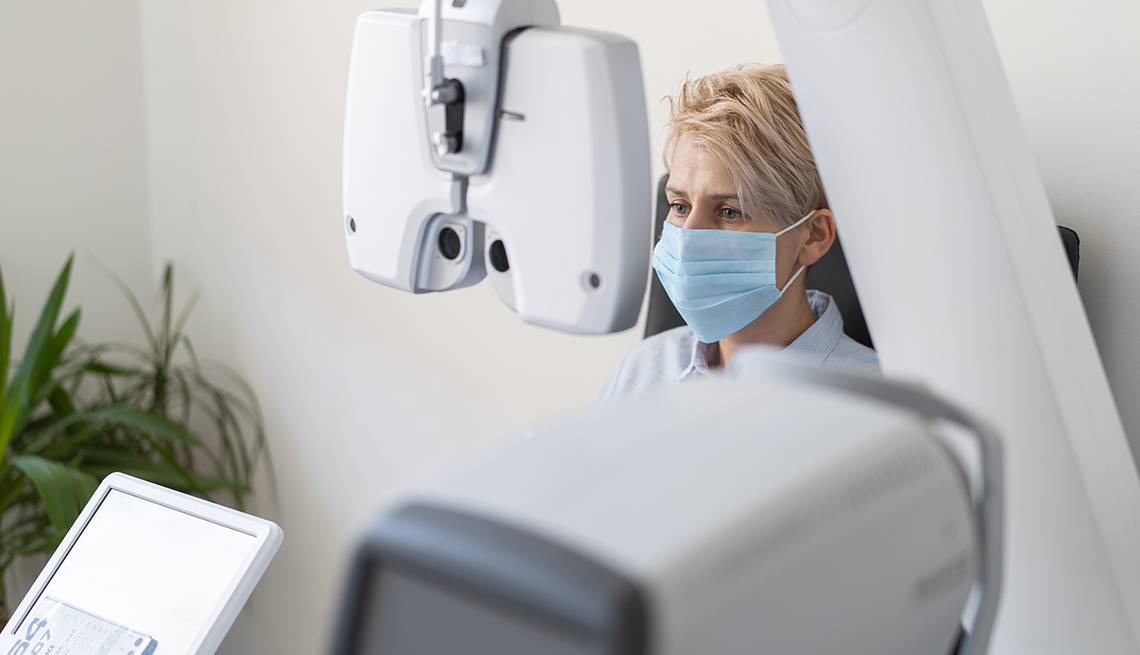 woman wearing a face mask and getting an eye exam