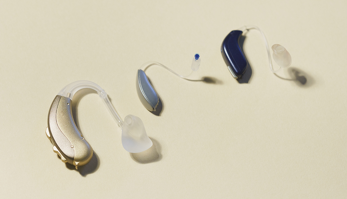 various hearing aids on a beige background