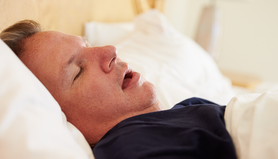 man asleep in bed and snoring