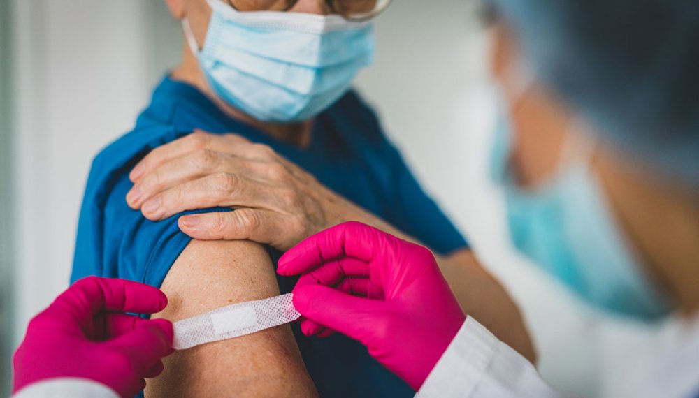 woman gets band aid after receiving vaccination