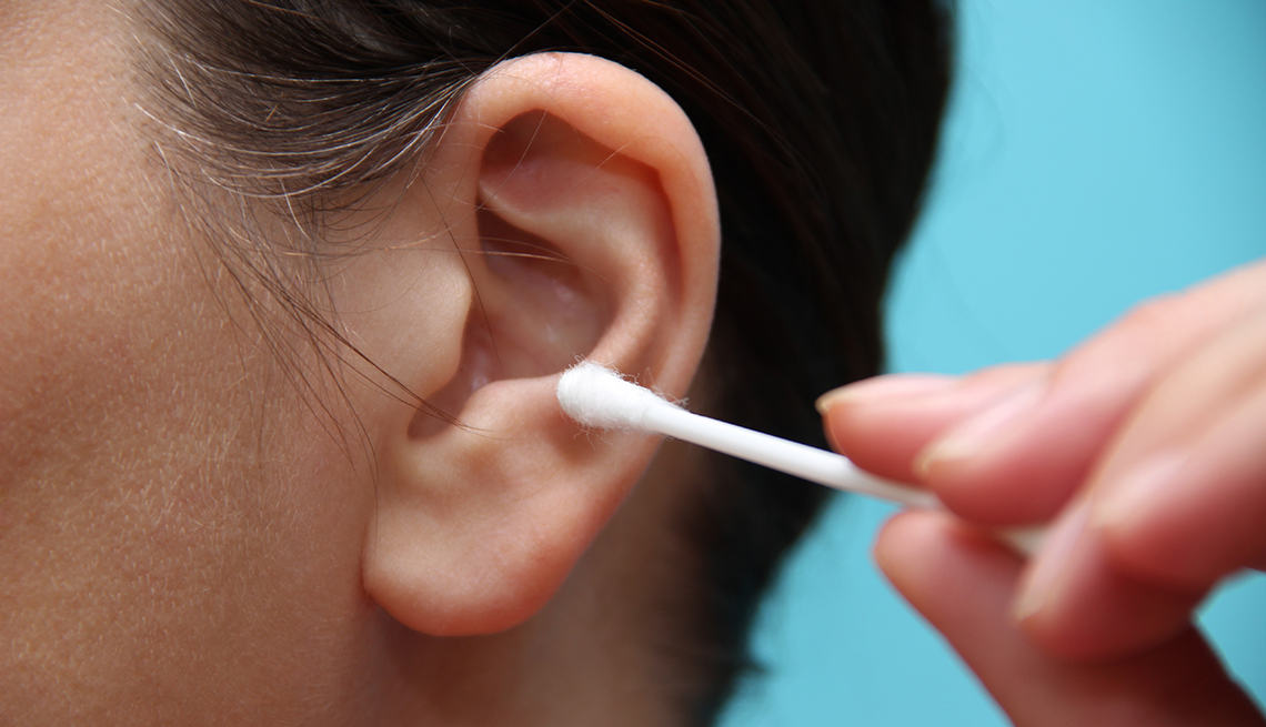 woman about to clean her ear with a q-tip