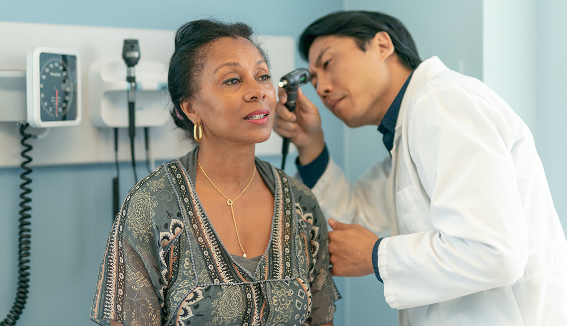Un médico examina los oidos de su paciente