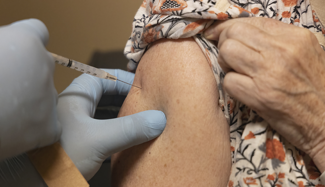 close up of a woman's arm as she receives a COVID vaccine booster