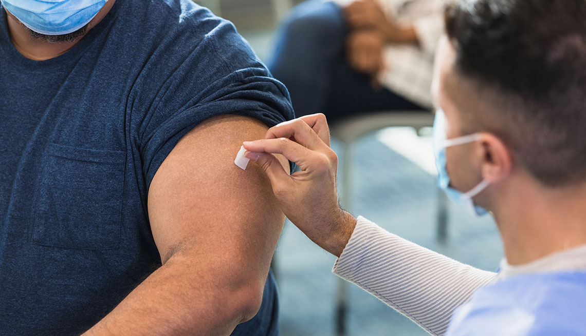 Un médico pasa un algodón sobre el brazo de una persona en preparación para una vacuna