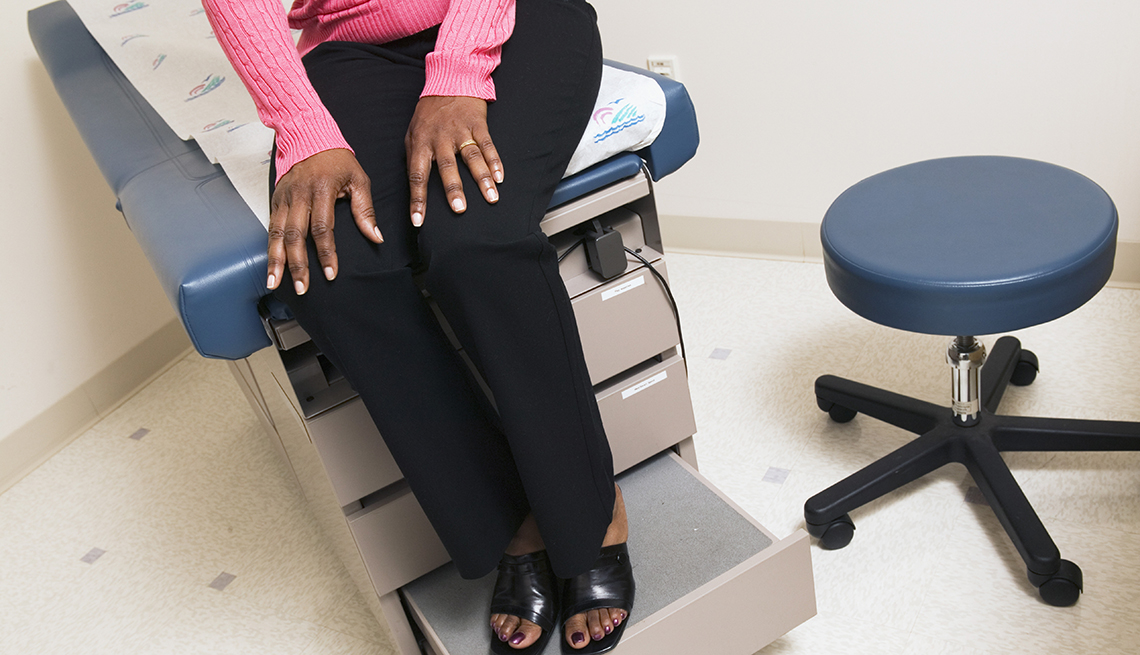Una mujer sentada en una camilla en un consultorio médico