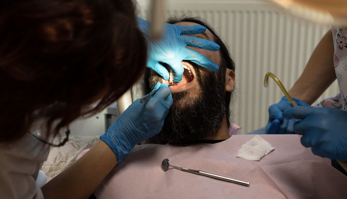 a man at a dentist receiving dental implants