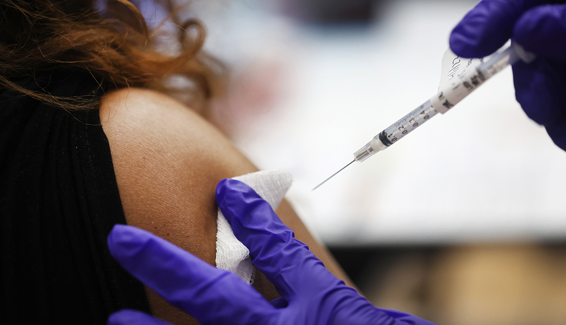 Una enfermera administra una vacuna a una mujer