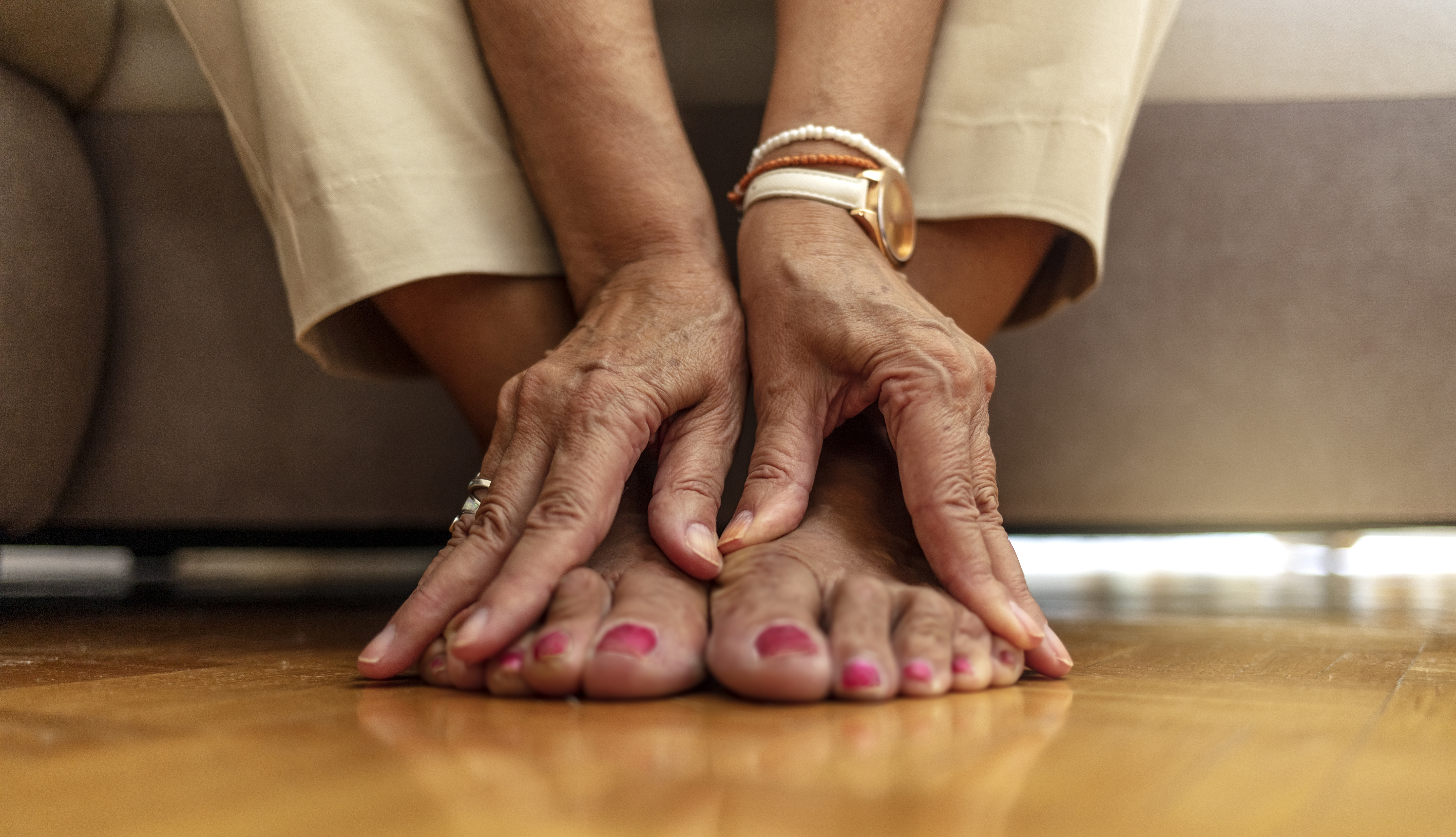 Una mujer masajea sus pies con ambas manos