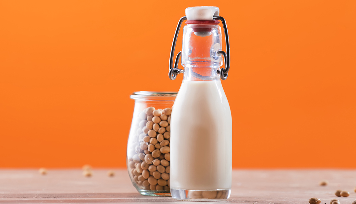 Soy milk and soy bean on orange background