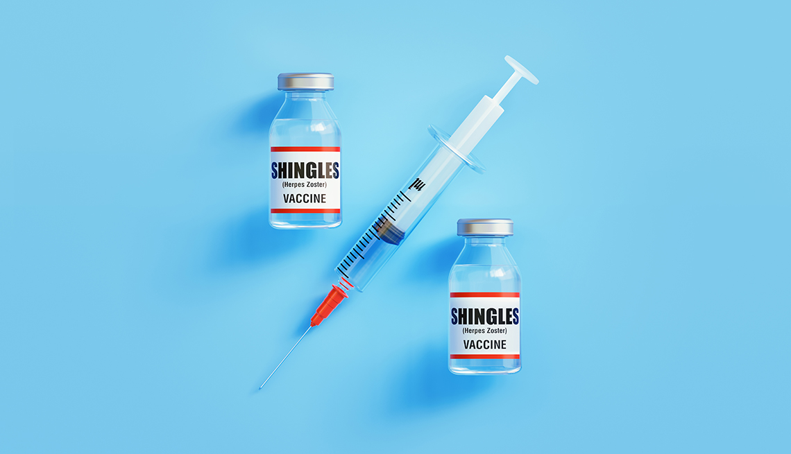 Dos frascos de vacunas contra la culebrilla y una jeringuilla sobre un fondo azul
