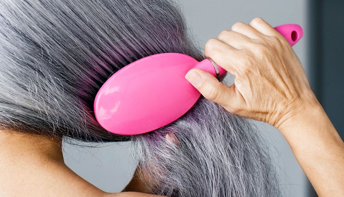 Una mujer cepillándose el cabello