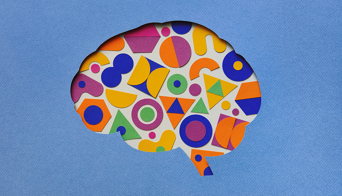 Cerebro humano formado por piezas en figuras geométricas hechas de papel sobre un fondo azul