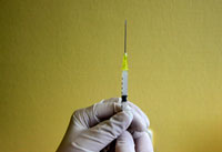 hands holding a needle with flu vaccine