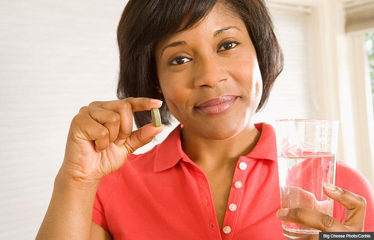 Woman holding Vitamin D pill, Blood pressure benefits