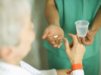 Nurse Bringing Patient His Medication, A drugmaker improperly marketed Megace to frail seniors in nursing homes.