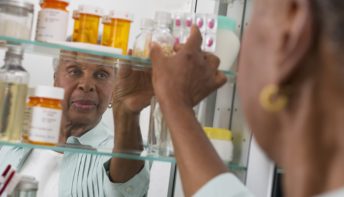 woman reaching into her medicine cabinet