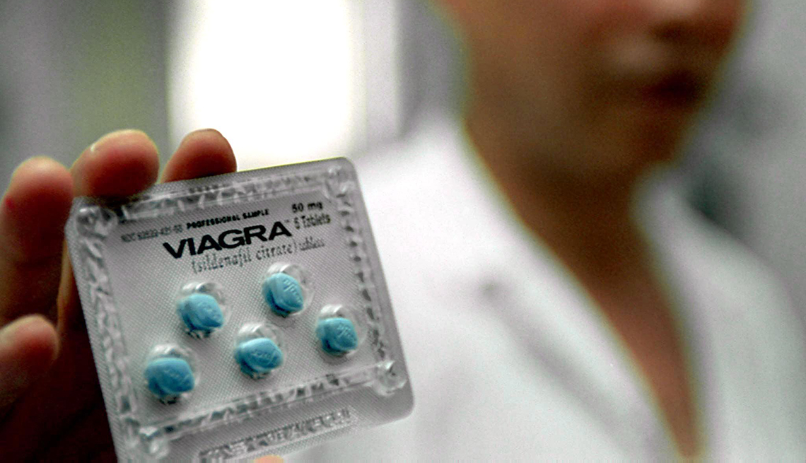 A pharmacist holding a package of viagra pills