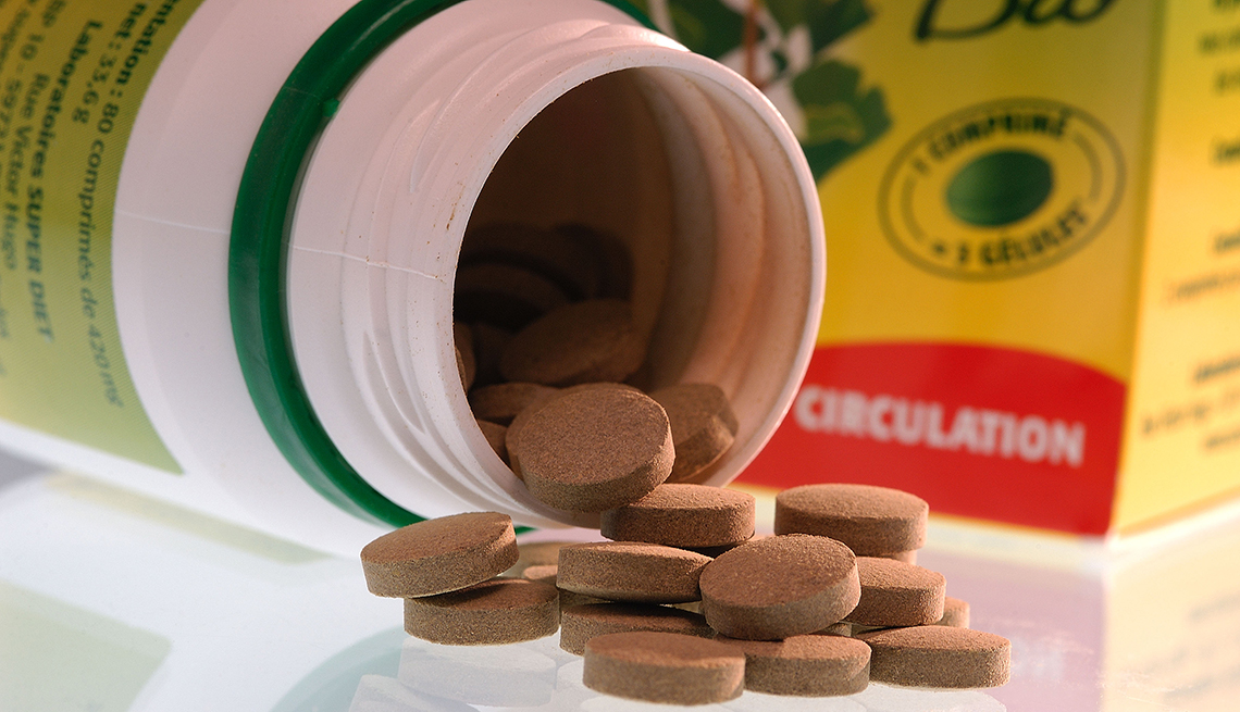 a bottle of organic nutritional supplements lying on its side with pills spilling out