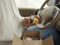 Man eating cupcake inside car