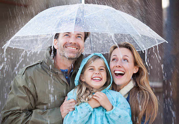 Enthusiastic family under protected under umbrella in a downpour. 10 Things You Need to Know About the Health Care Law