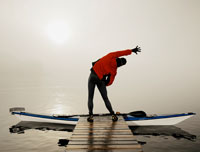A kayaker stretches before entering his boat