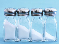 Several shakers containing varying amounts of salt. Sodium intake can contribute to high blood pressure. 