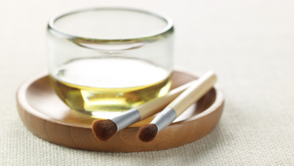 olive oil in a jar and two nail brushes
