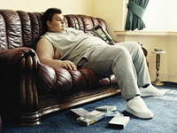 Obese person on sofa- interactive map shows rates for physical inactivity in each state and D.C.