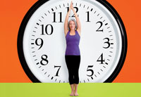 Woman stands in front of a giant clock - Dr. Oz 24 hours to a longer life