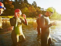 Group of triathletes in water preparing for swim -  Mini triathalons are the new fitness trend     