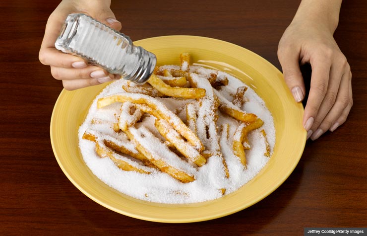 Woman over-salting junk food, We Still Consume Too Much Sodium