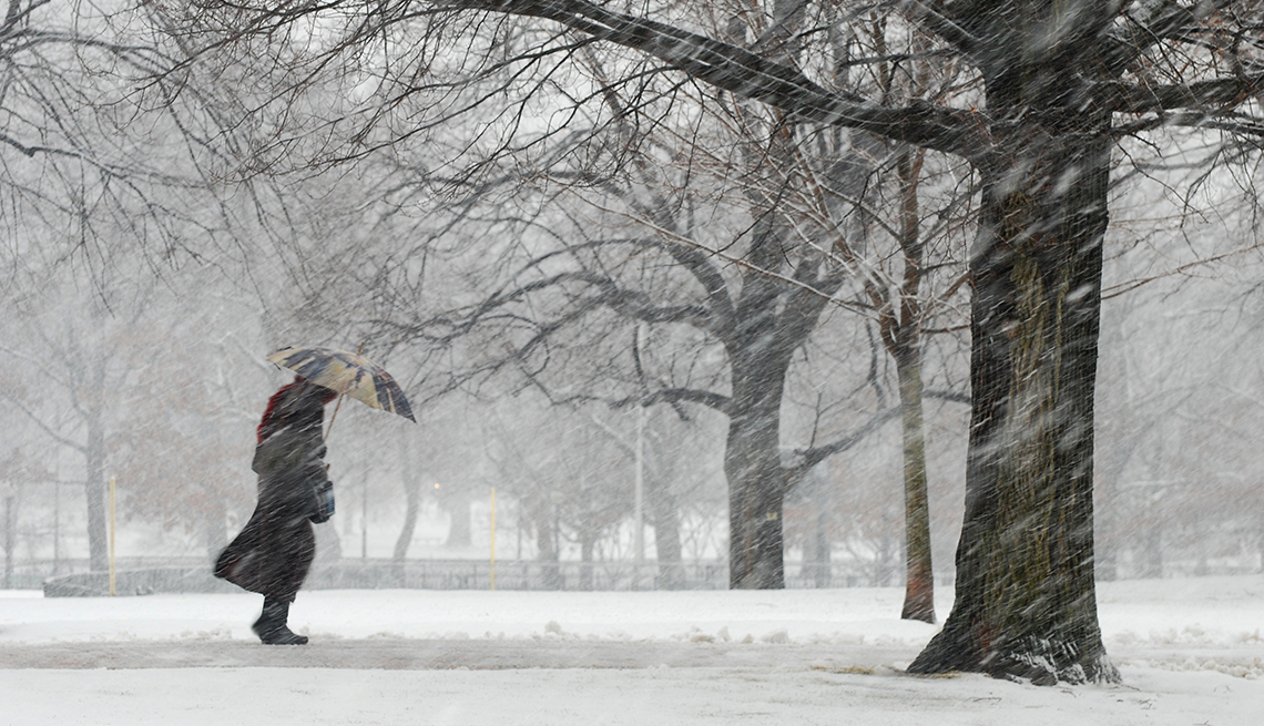 Persona caminando bajo una tormenta de nieve