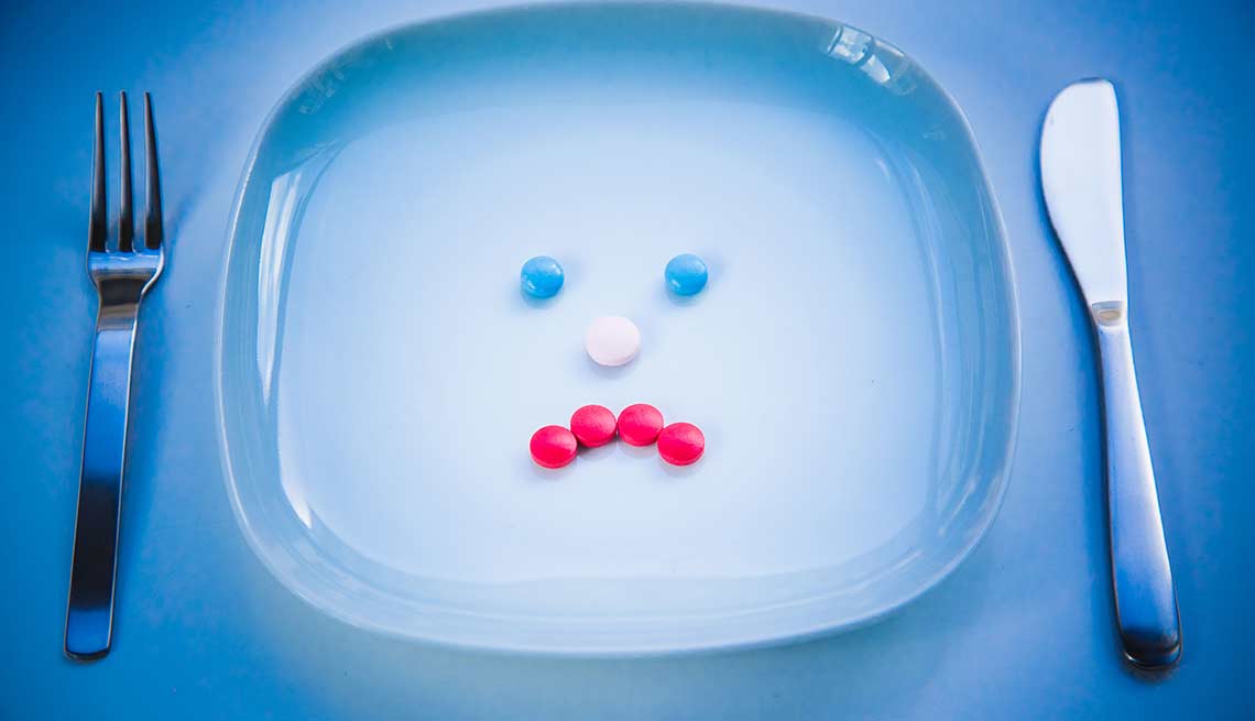 Pills in an unhappy face on a plate, food drug interaction