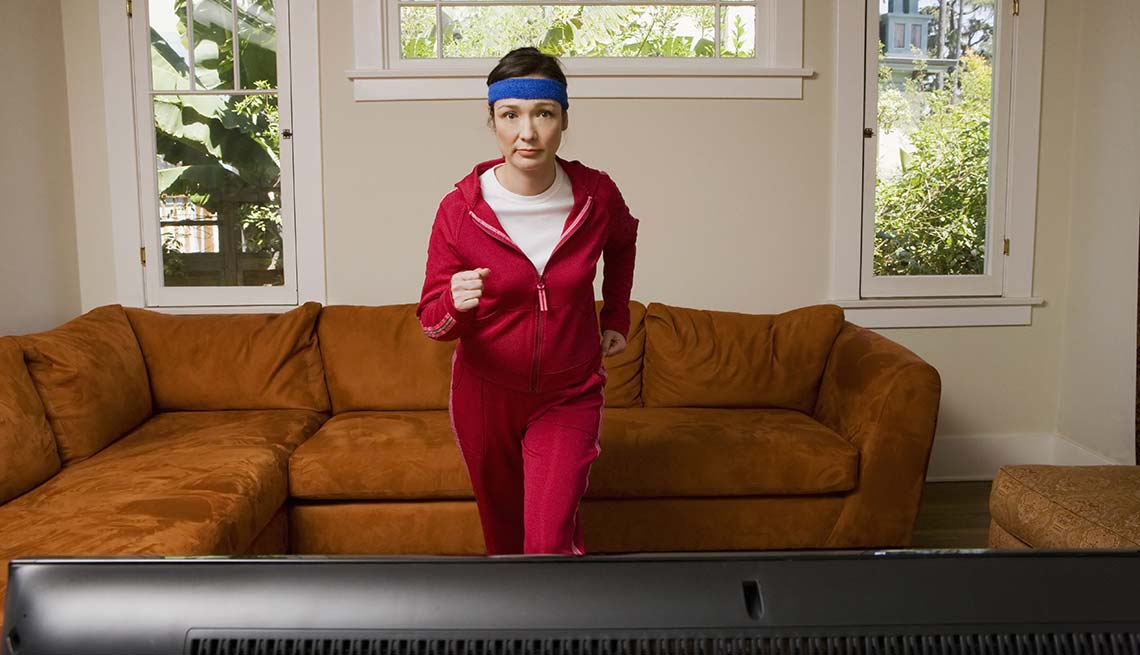 Mujer haciendo ejercicios frente al televisor