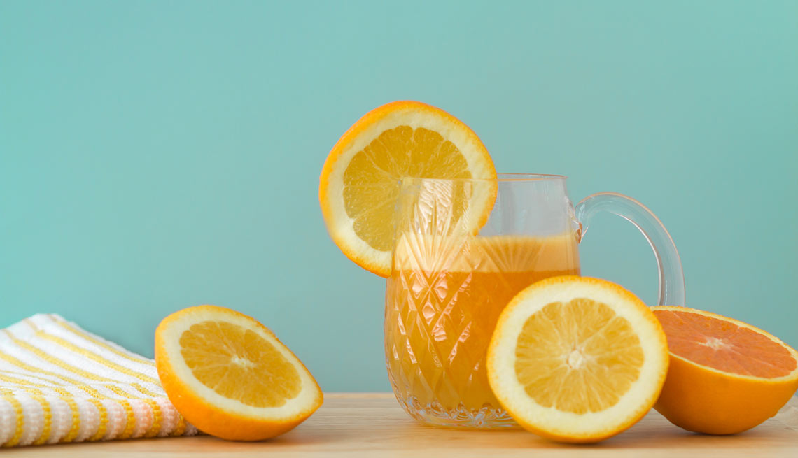 Naranjas cortadas a la mitad y jugo de naranja servido - Efecto del azúcar en el cuerpo