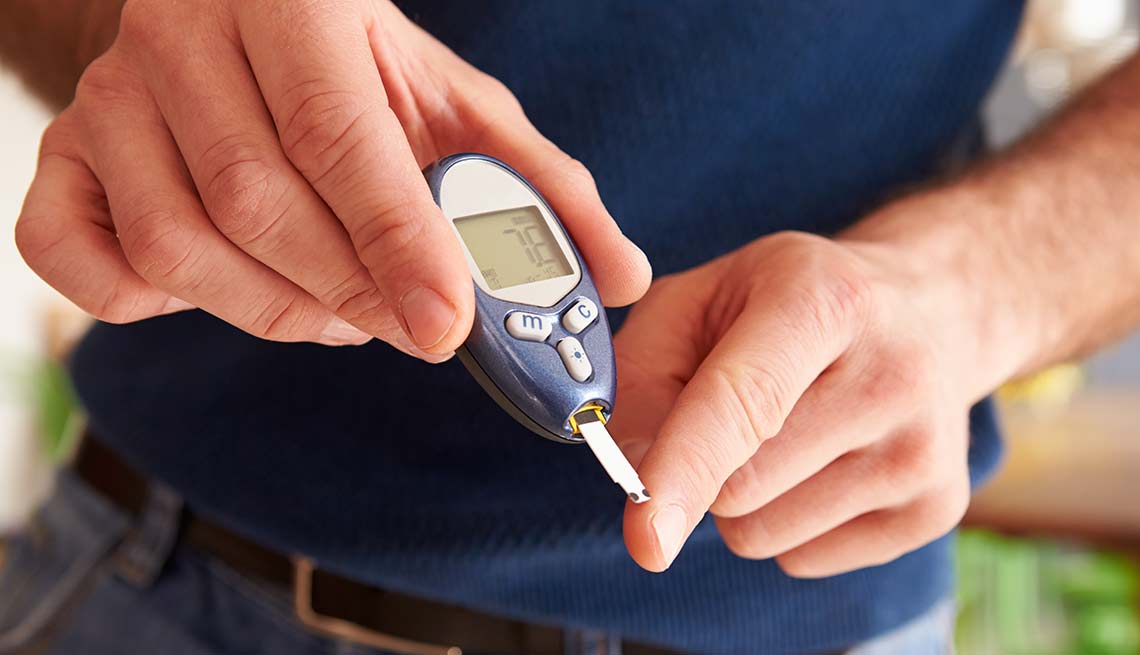 Hombre monitoreando su diabetes con un glucómetro
