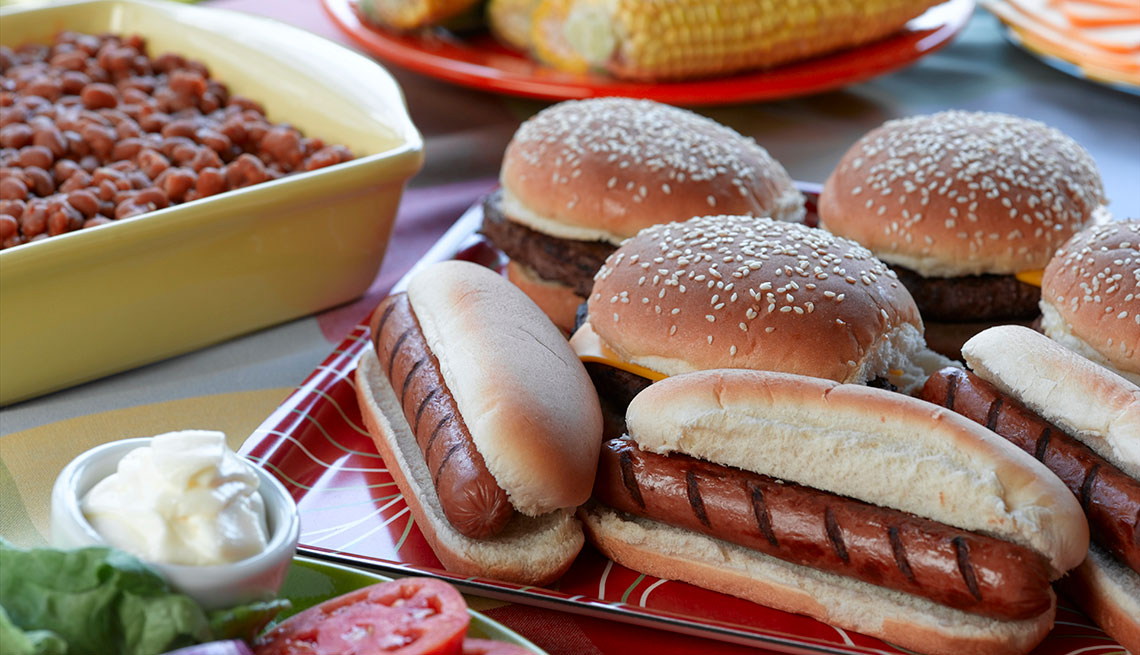 Hot Dogs, habichuelas, ensalada y maíz sobre una mesa de picnic