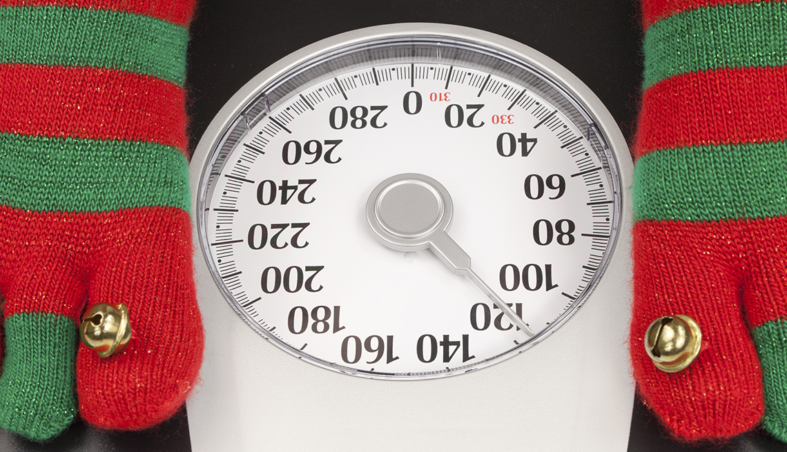 Christmas socks on a scale, weight gain holiday season, How Not to Gain Those 10 Holiday Pounds