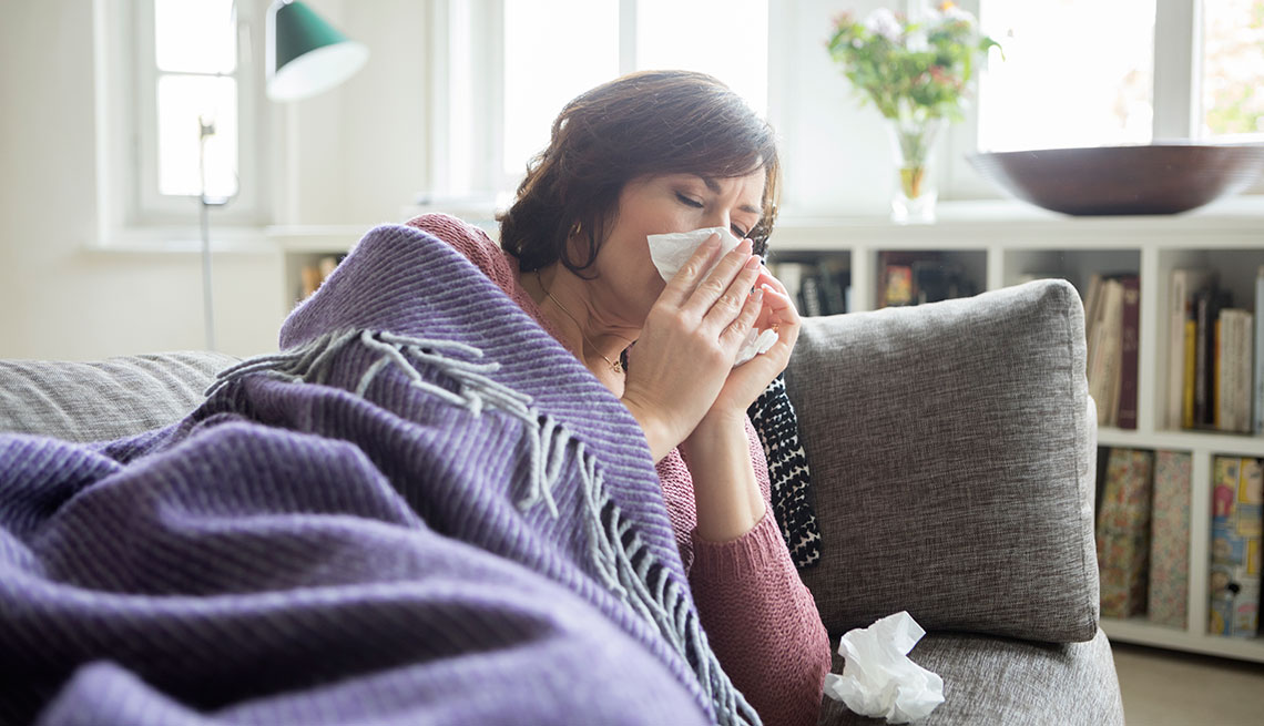 Mujer con gripe acostada en un sofá