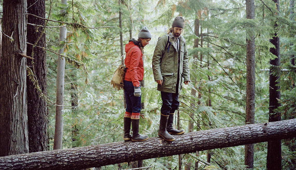 Male And Female Hikers Stand On Fallen Tree Trunk In Forest, What Is Your Courage Quotient?