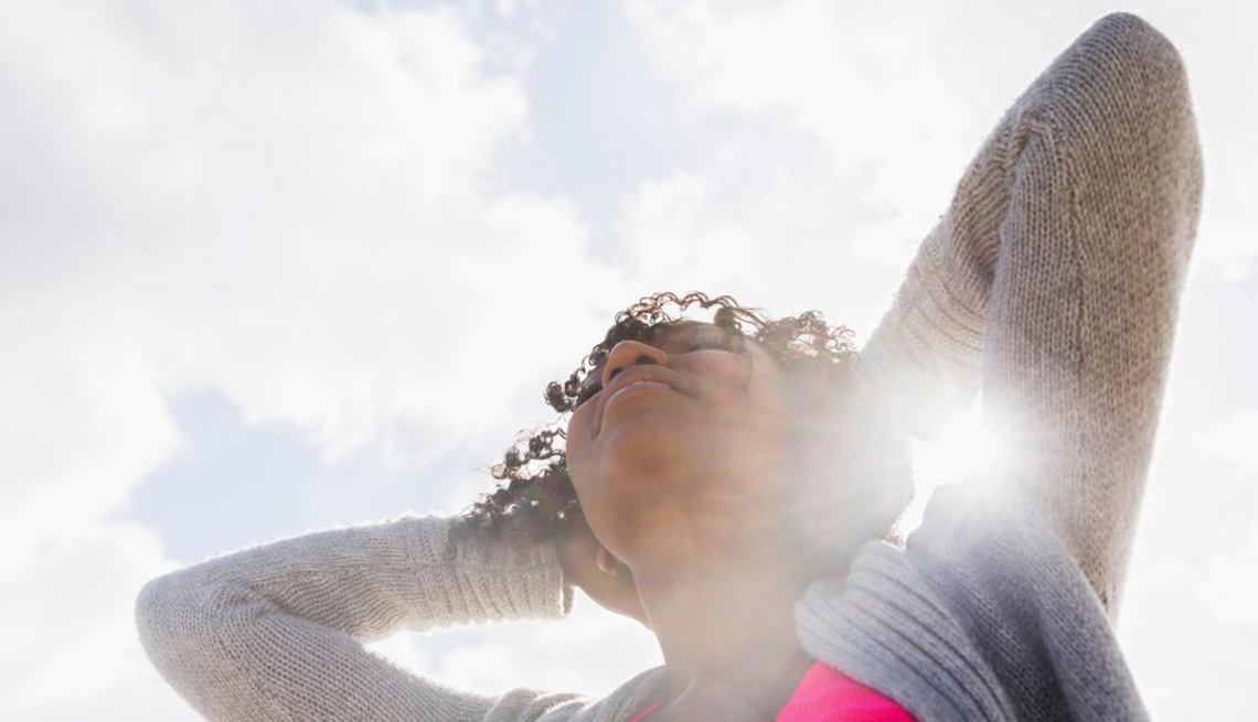 Woman stretching outside in sunshine, Healthy Living, Vitamin D Isn’t Just Good For Your Bones