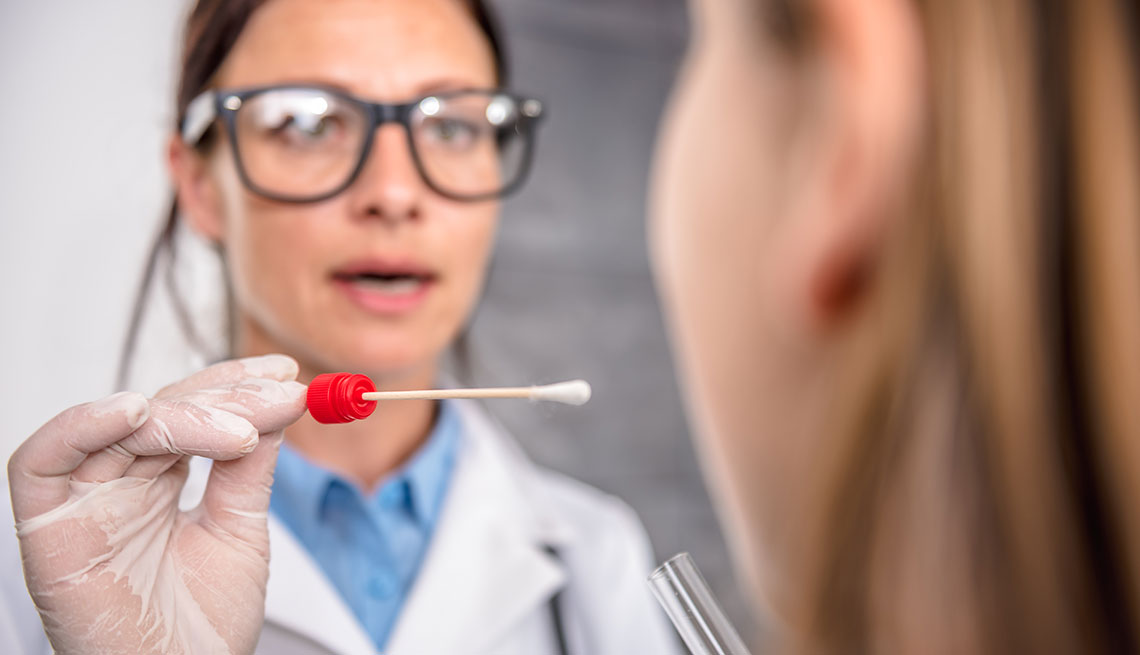 Doctor using a swab to take a sample from a patient's throat
