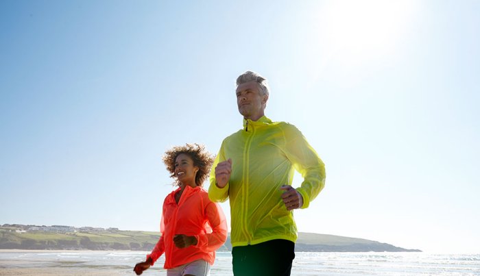Couple jogging on a deserted beach.
