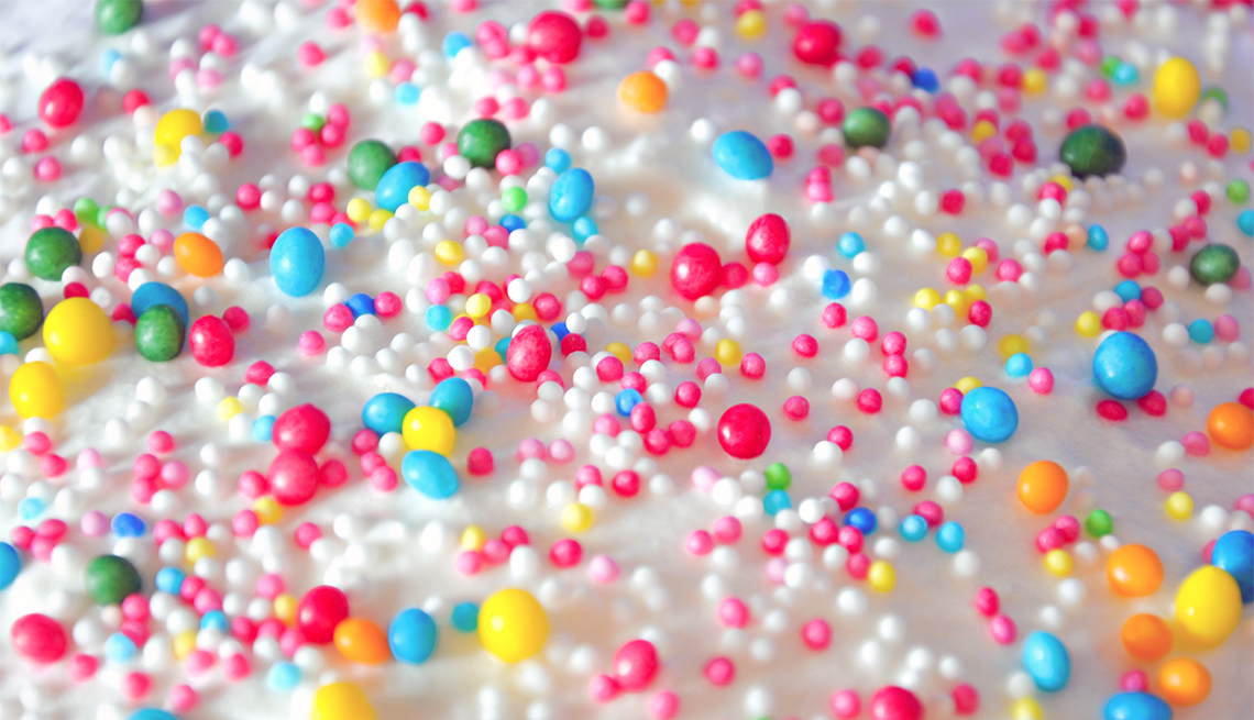 Pastel cubierto de una capa azucarada y lluvia de colores