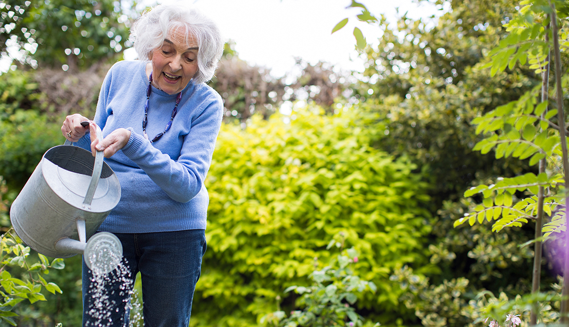 Mujer mayor regando sus plantas