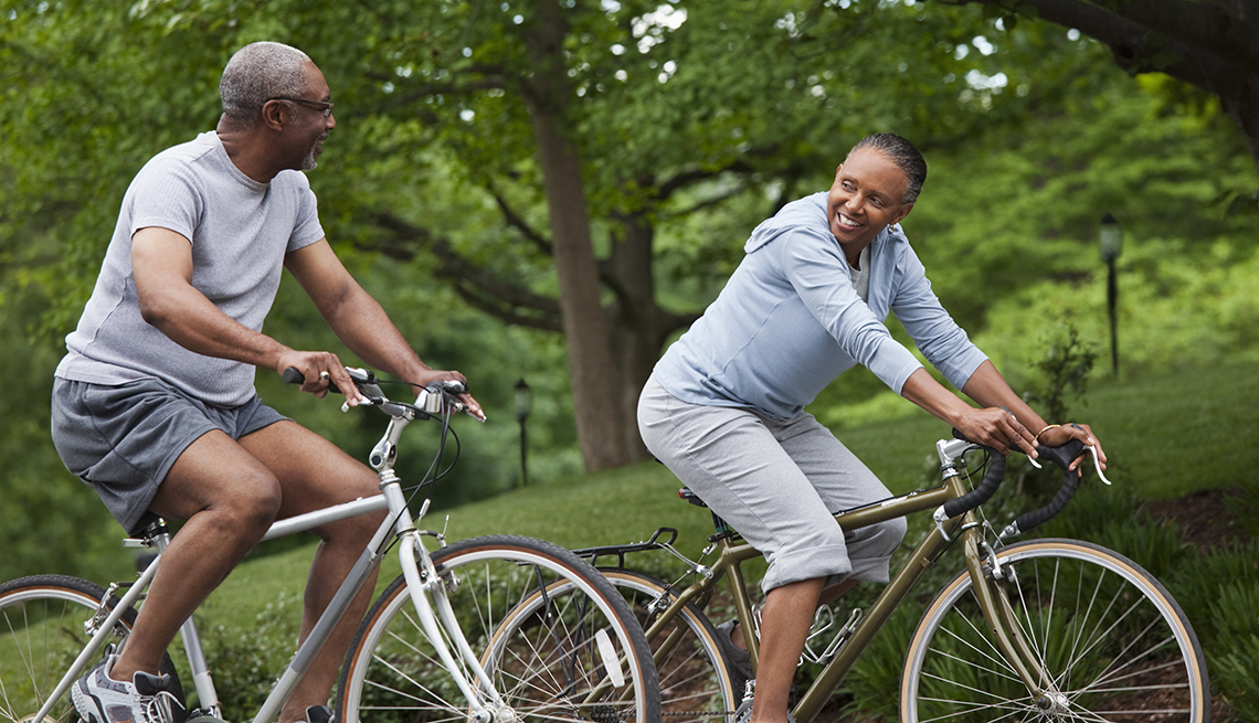Couple riding bikes along a wooded path