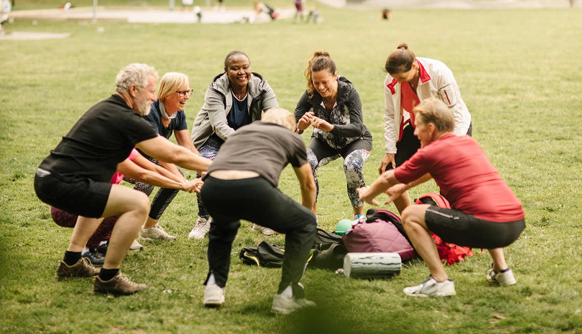 Group of adults in a circle exercising outdoors