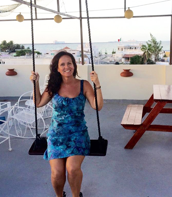 sonya vangelderen sits on a swing on a patio with a view of the ocean